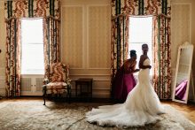 bride being helped in to her dress by her mother