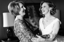 bride and her mother share a moment after bride puts on her wedding dress by Detroit wedding photograher Heather Jowett