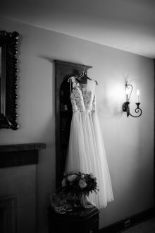 Black and white photo of a wedding dress hanging