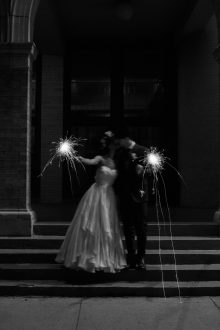 a couple kisses while holding sparklers