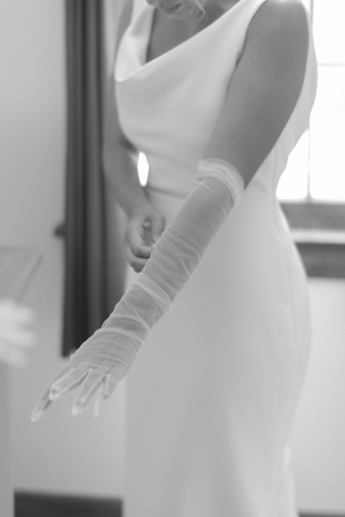 Bride pulling on bridal gloves.