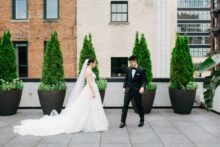Candid moment from the couples first look on the rooftop terrace of the Shinola Hotel in Detroit captured with a timeless documentary feel against the citys signature backdrop