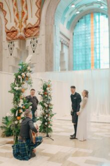the bride and groom laugh as their friends serenade them with a traditional scottish song