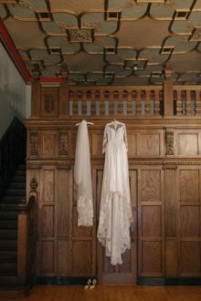 Heirloom wedding dress and lace veil hanging captured in a fine art documentary style for a timeless Masonic Temple wedding