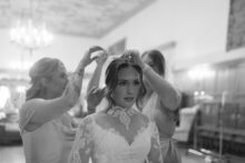 Bridesmaids securing the brides veil in soft light before her ceremony at Saints Peter and Paul Jesuit Church