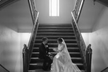 Fine art black and white photo of the couple reading vows on the marble staircase of the Detroit Masonic Temple