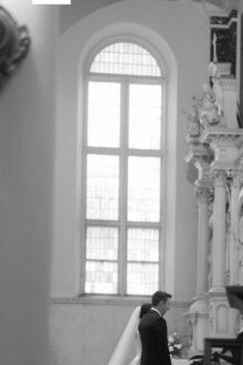 Artful black and white image of the bride and groom at the altar of Saints Peter and Paul Jesuit Church in Detroit