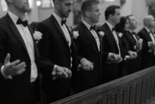 Guests standing in prayerful stillness during the Catholic wedding ceremony at Saints Peter and Paul Jesuit Church an intimate moment in this fine art Detroit wedding