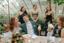 Bride and groom laighng together during speeches