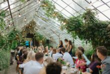 wide shot of a wedding reception in the greenhouse at Glass House Community