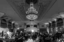 Black and white wide angle view of a full wedding reception in the Crystal Ballroom at the Detroit Masonic Temple photographed by Luxury Detroit wedding photographer Heather Jowett