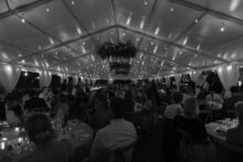 Wide shot of the guests eating dinner in the tent at the Perry hotel