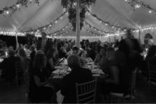 Guest seated for dinner during a tented wedding reception.
