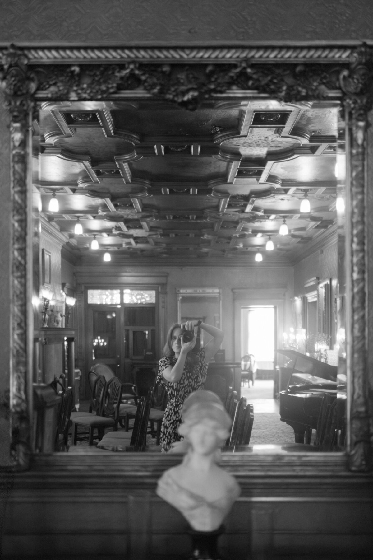 Artist portrait of Heather Jowett photographed in the mirror at the David Whitney Hotel.
