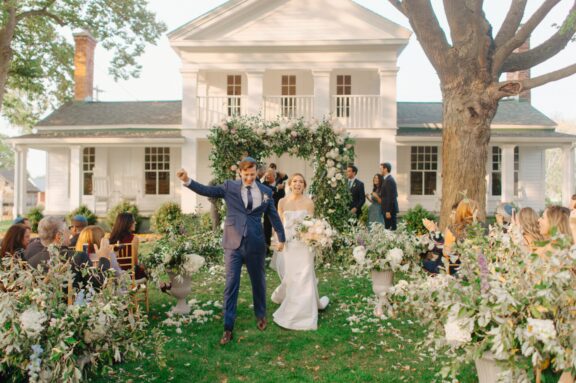 A bride and groom celebrating as they walk back down the aisle at their Cornman farms wedding ceremony.